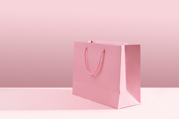 Borsa della spesa di carta su sfondo rosa Concetto di consegna di vendita di acquisto