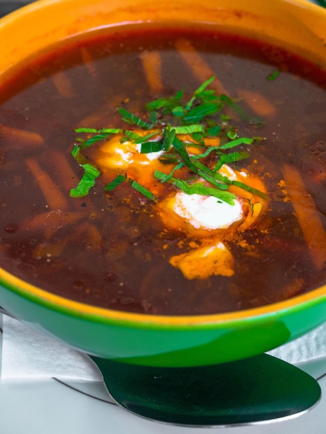 Borsch tradizionale ucraino Zuppa rossa vegetariana russa in ciotola bianca su sfondo di legno Vista dall'alto