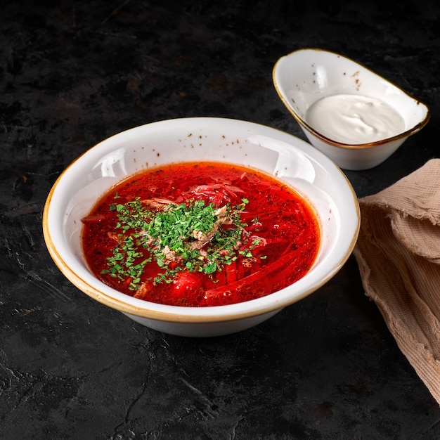 Borscht russo ucraino tradizionale. Ciotola di zuppa di barbabietola rossa borsch con crema bianca. Zuppa deliziosa di radice di barbabietola. Cucina tradizionale ucraina