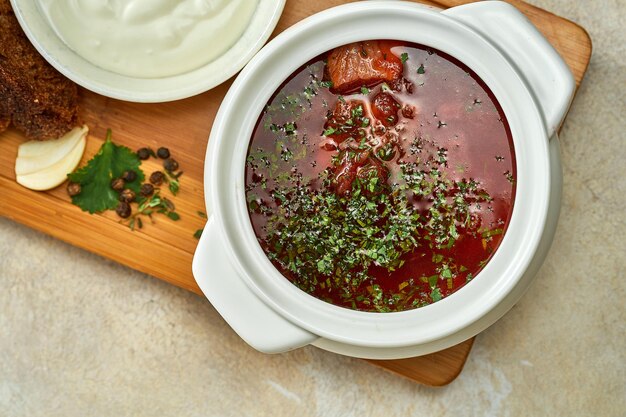 Borscht ucraino con lardo e pane, panna acida in un piatto. Primo piano, fuoco selettivo