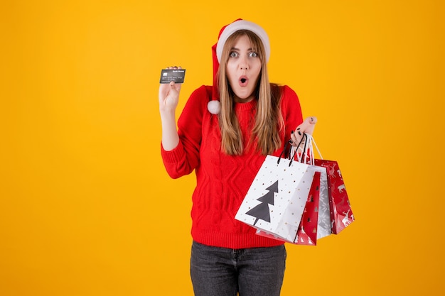Borse emozionanti della carta di credito del modello della tenuta della ragazza e del regalo di acquisto di festa che portano il cappello di Santa