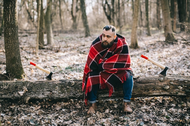 Boscaiolo in plaid seduto sul registro