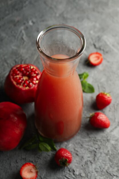 Bottiglia - brocca con succo di melograno su grigio