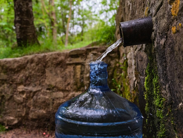 Bottiglia con acqua di sorgente naturale fresca e fredda proveniente da una sorgente