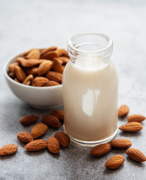 Bottiglia con latte di mandorla e mandorle in tavola