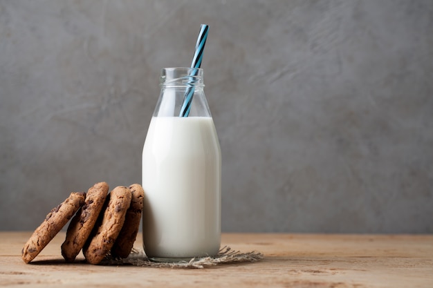 Bottiglia con latte e biscotti con gocce di cioccolato.