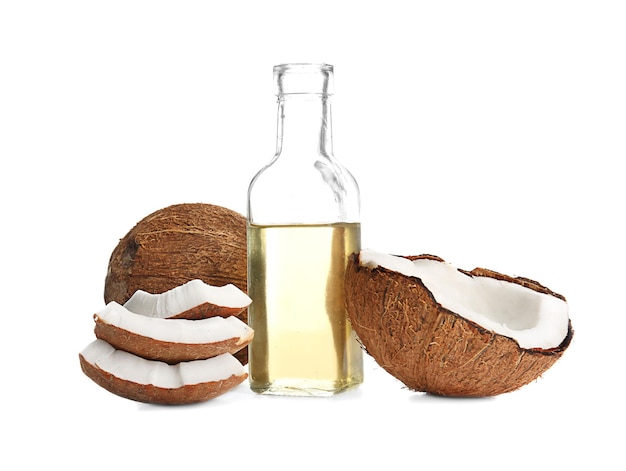 Bottiglia con olio di cocco fuso e noci su sfondo bianco