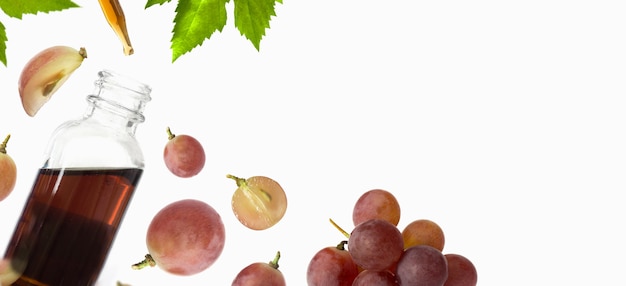 Bottiglia con olio di semi d'uva rossa su sfondo biancospazio copia piatta vista dall'alto