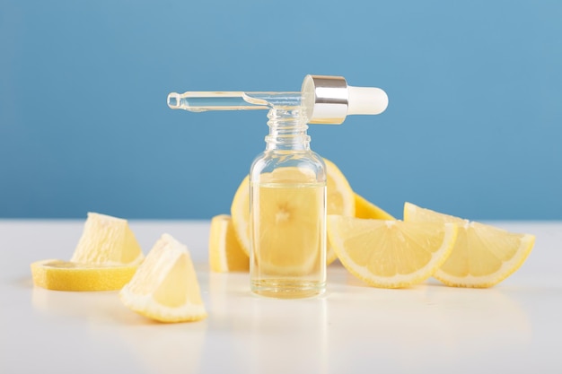 Bottiglia con olio essenziale di limone con fette di limone sul tavolo Olio o siero di agrumi cosmetici Concetto di medicina naturale Aromaterapia