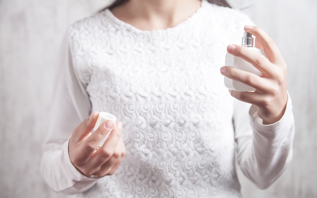 Bottiglia della holding della ragazza di profumo.