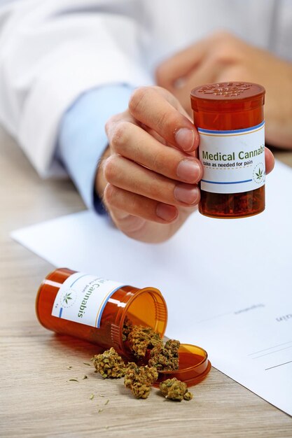 Bottiglia della tenuta della mano del medico con la cannabis medica si chiuda