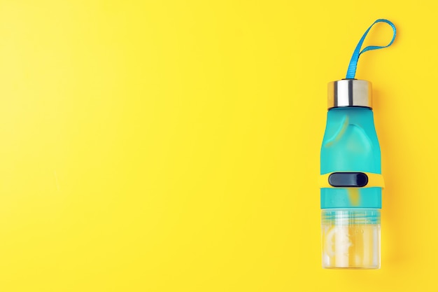 Bottiglia di acqua di limone su sfondo giallo