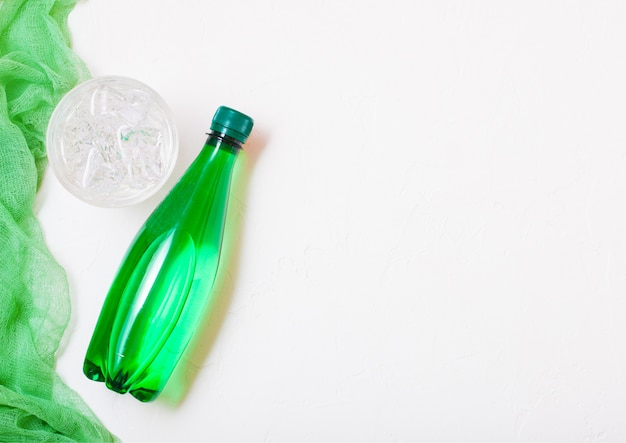 Bottiglia di acqua minerale frizzante e un bicchiere di ghiaccio
