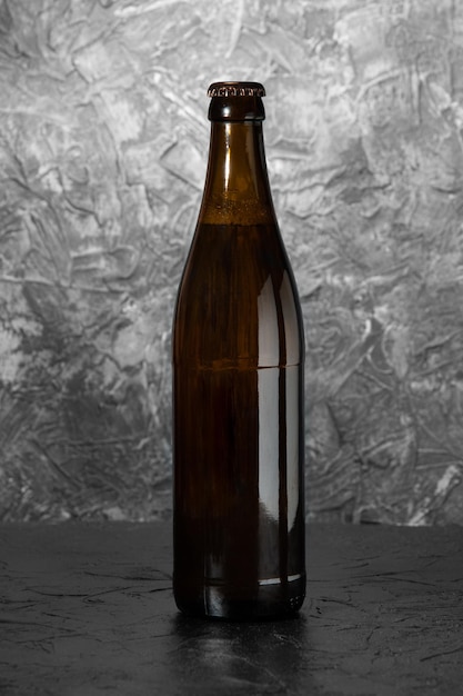 Bottiglia di birra su sfondo grigio scuro