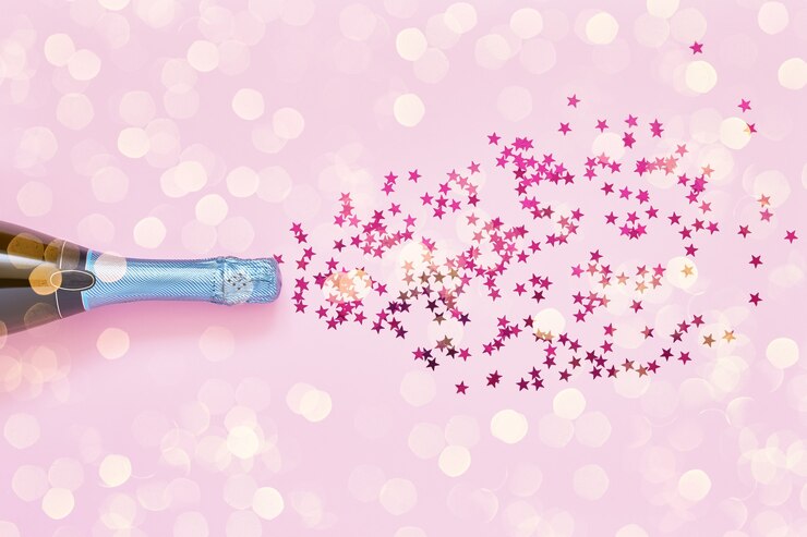 Bottiglia di champagne blu con coriandoli rosa su sfondo rosa. Lay piatto del concetto di celebrazione di Natale, Capodanno o addio al nubilato. Copia spazio per il testo.