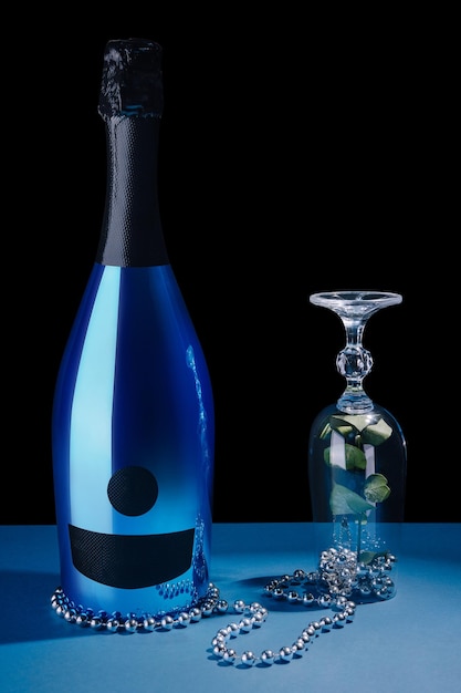 Bottiglia di champagne blu con vetro e fiore