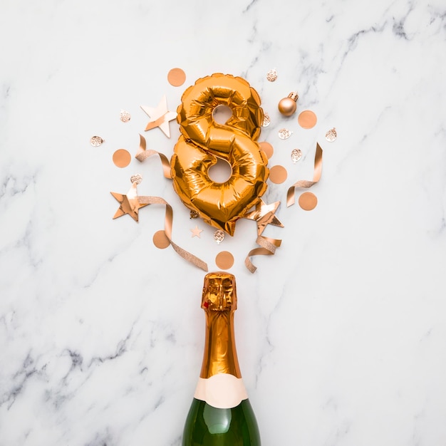 Bottiglia di champagne con palloncino con numero d'oro concetto di anniversario di festa minimo