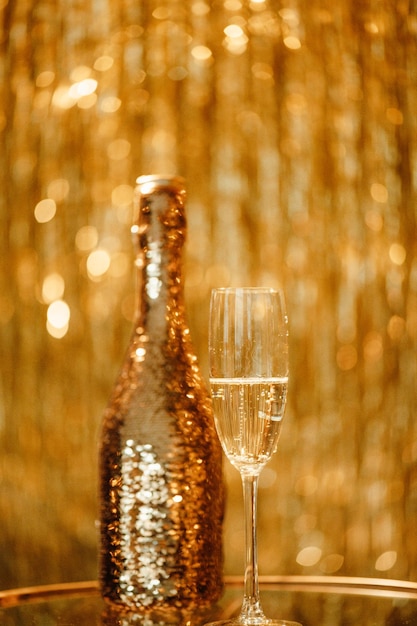 Bottiglia di champagne e bicchieri contro il lusso bagliore pioggia dorata decorazione festa costosa vacanze