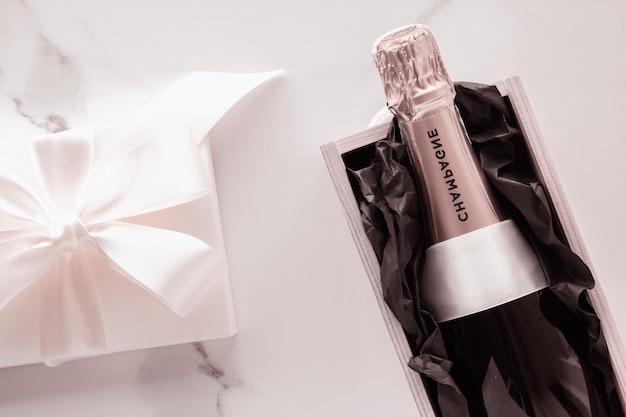 Bottiglia di champagne e confezione regalo su marmo Capodanno Natale San Valentino o regalo di festa di nozze e confezione di prodotti di lusso per il marchio di bevande