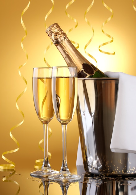 Bottiglia di champagne nel secchio con ghiaccio e bicchieri di champagne