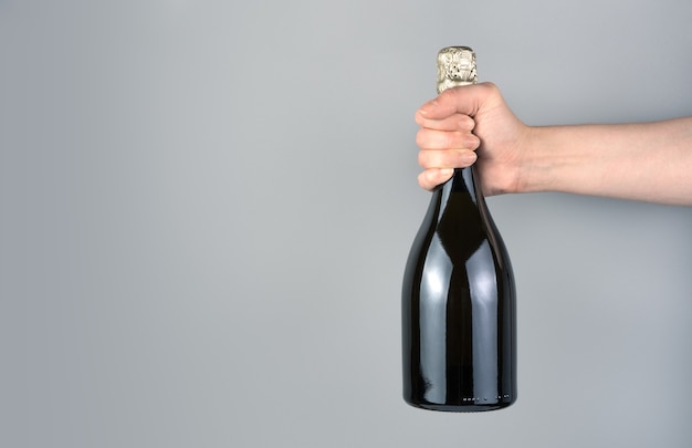 Bottiglia di champagne sulla mano di un uomo