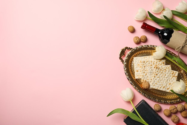 Bottiglia di matzo di fiori di vino e Torah su sfondo rosa spazio per il testo