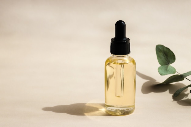 Bottiglia di olio essenziale cosmetico closeup con ombre profonde Messa a fuoco selettiva Concetto di bellezza