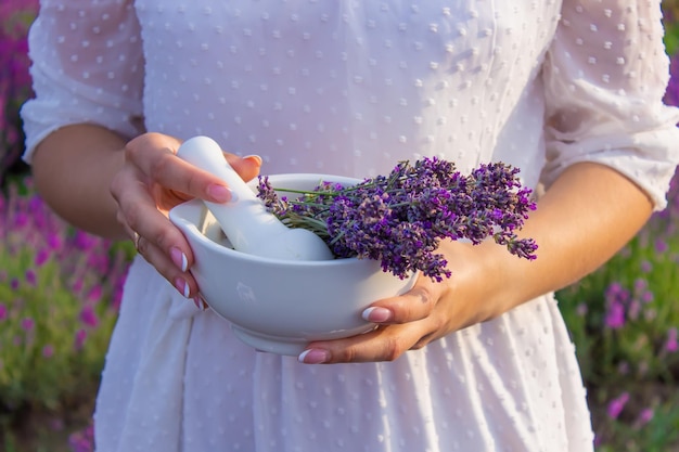 Bottiglia di olio essenziale di lavanda su tavola di legno e sfondo di campo di fiori