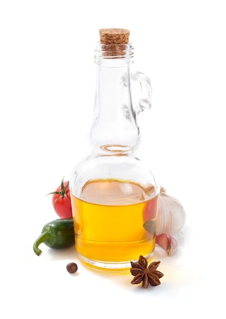 Bottiglia di olio isolata e spezie su fondo bianco