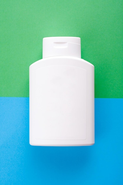 Bottiglia di plastica bianca bianca su sfondo blu e verde