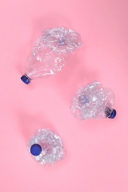 Bottiglia di plastica deformata sul rosa