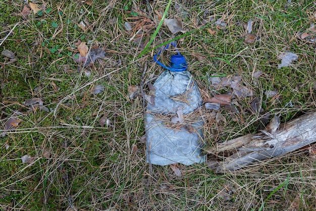 Bottiglia di plastica usa e getta usata nella foresta. Ambiente di inquinamento. Rifiuti di plastica a lunga decomposizione.