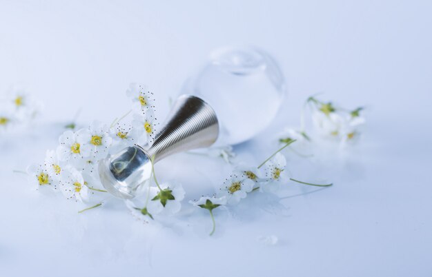 Bottiglia di profumo con profumo di fiori su sfondo bianco