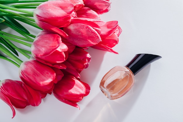 Bottiglia di profumo con tulipani rosa. Fragranza floreale. Concetto di cosmetici naturali. Regalo per donna