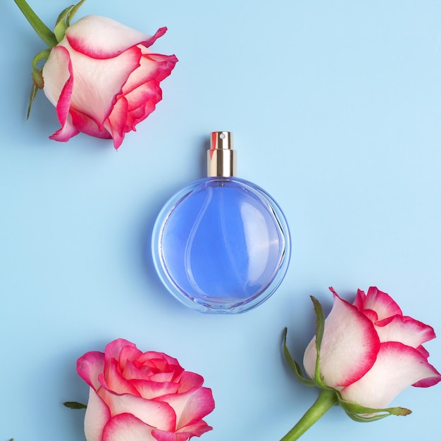 Bottiglia di profumo e fiori di rosa Concetto di profumo e cosmetici costosi Fragranza floreale per le donne Spray di profumo