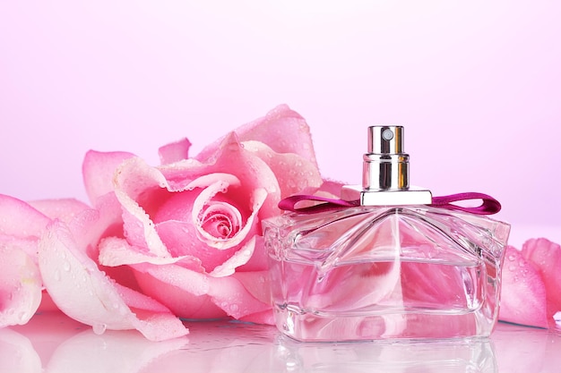 Bottiglia di profumo e rosa rosa su rosa