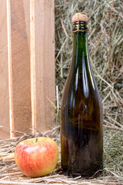 Bottiglia di sidro con una mela e una cannuccia