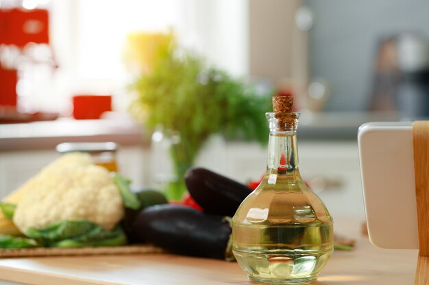 Bottiglia di vetro di olio sul bancone della cucina in legno