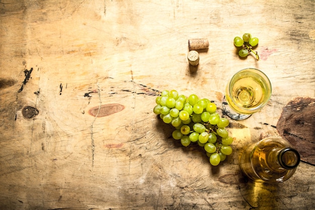 Bottiglia di vino bianco con tappi di sughero. Sullo sfondo di legno.