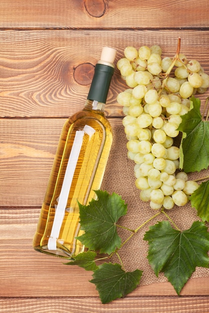 Bottiglia di vino bianco e grappolo d'uva bianca