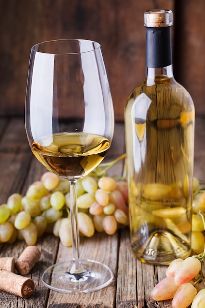 Bottiglia di vino bianco, uva e tappi di sughero