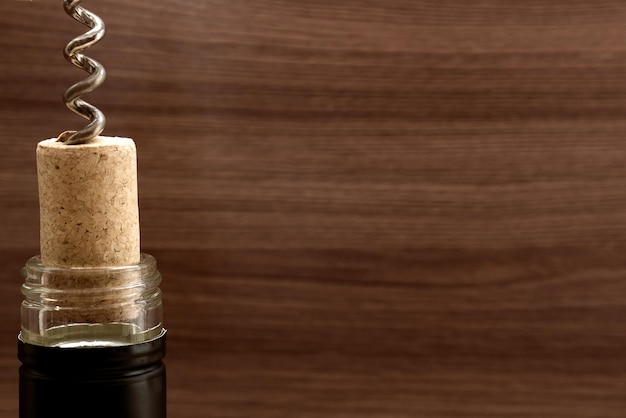 Bottiglia di vino con tirocinetto su sfondo di legno