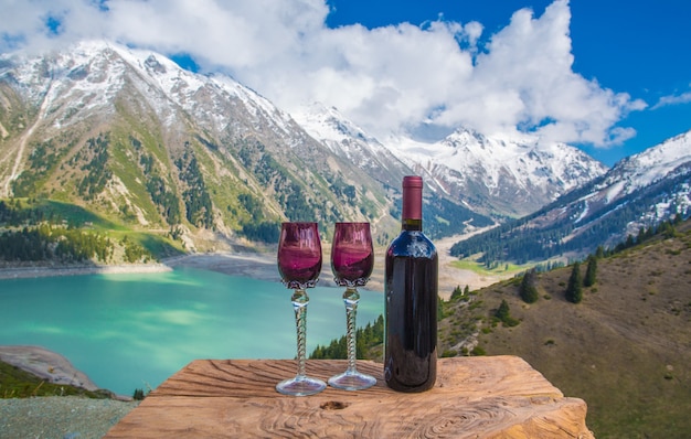 bottiglia di vino e bicchieri lago di montagna