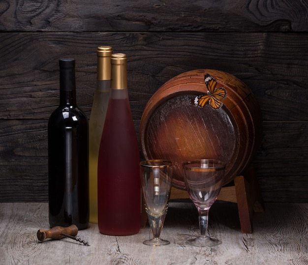 bottiglia di vino e botte di legno per vino su un tavolo di legno still life wine tavern
