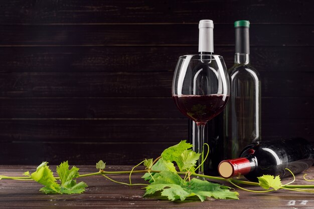 Bottiglia di vino e uva sul tavolo di legno