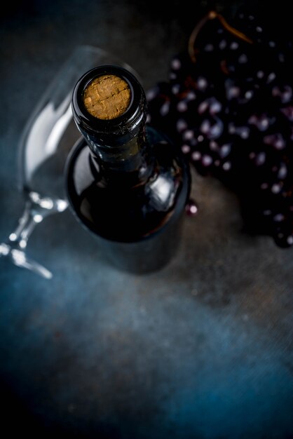 Bottiglia di vino rosso con vetro e uva