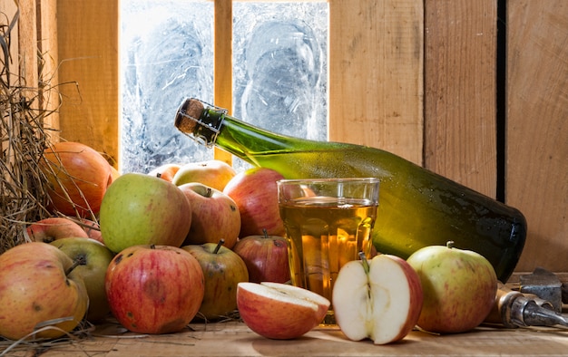 Bottiglia e bicchiere di sidro con mele