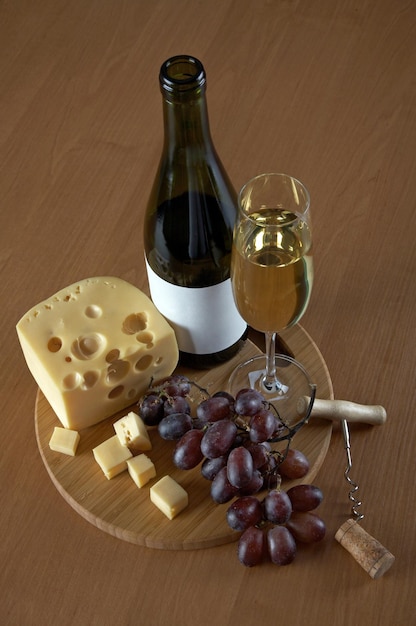 Bottiglia e bicchiere di vino bianco con formaggio