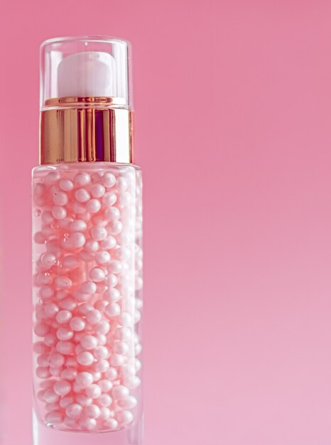 Bottiglia per la cura della pelle su sfondo rosa prodotti cosmetici e di bellezza di lusso