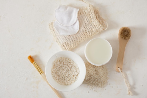 Bottiglie bianche mockup di cosmetici ciotole di riso e acqua prodotti per la cura della pelle e dei capelli fermentati cosmetici biologici